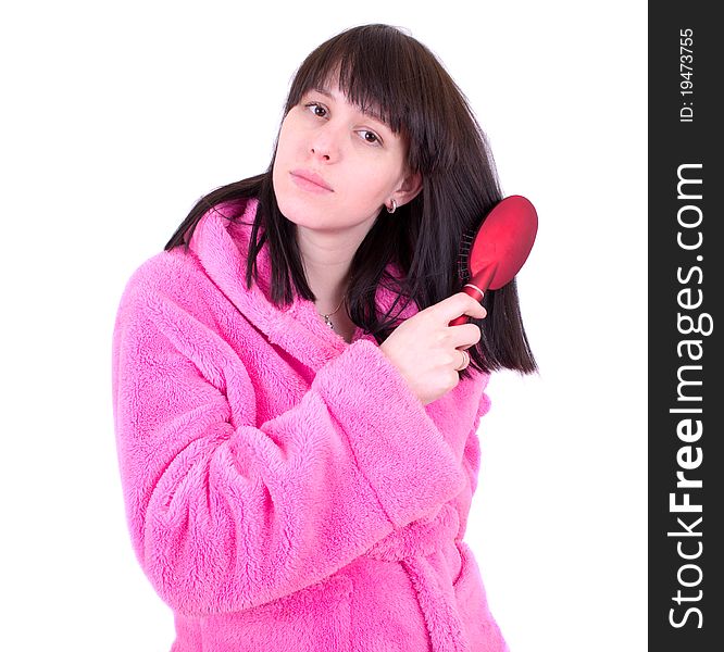 The young woman in a dressing gown combs hair a hairbrush. The young woman in a dressing gown combs hair a hairbrush