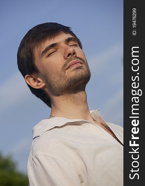 Man in linen shirt enjoying sunset over blue sky. Man in linen shirt enjoying sunset over blue sky