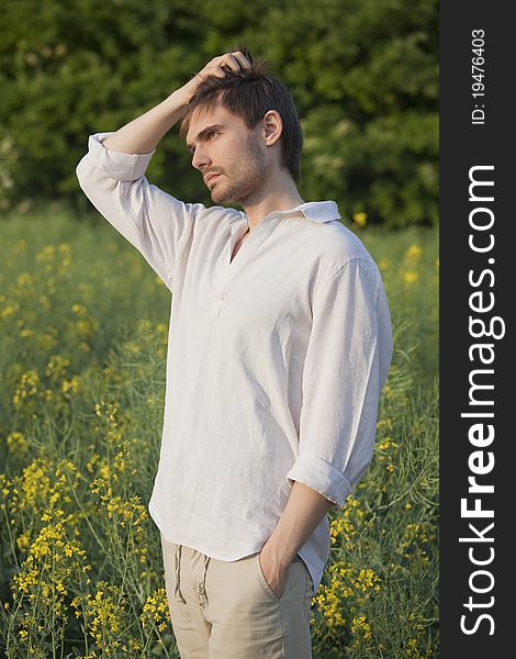 Man in linen shirt and trousers standing in field. Man in linen shirt and trousers standing in field