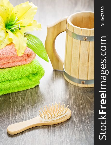 Studio shot closeup nobody view on the bathing comopsition yellow wooden mug cotton colored towels flover with leaves hairbrush wooden board. Studio shot closeup nobody view on the bathing comopsition yellow wooden mug cotton colored towels flover with leaves hairbrush wooden board