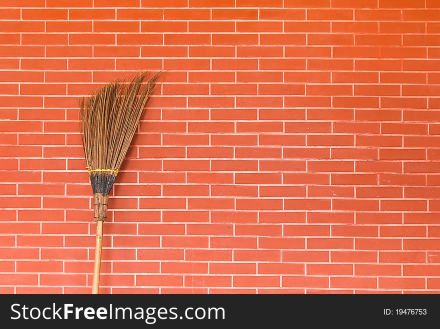 Broom on brick wall