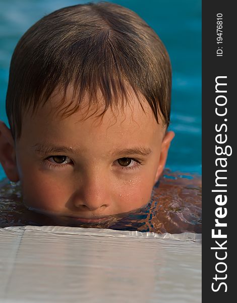 Portrait of a boy in a pool half face in the water. Portrait of a boy in a pool half face in the water