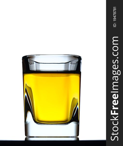 Whisky shot on a black reflective surface