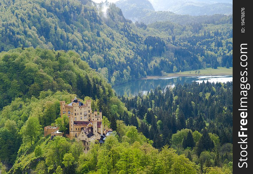View of the medieval castle of Hohenschwangau and Alpsee lake on the background of the Alps. View of the medieval castle of Hohenschwangau and Alpsee lake on the background of the Alps