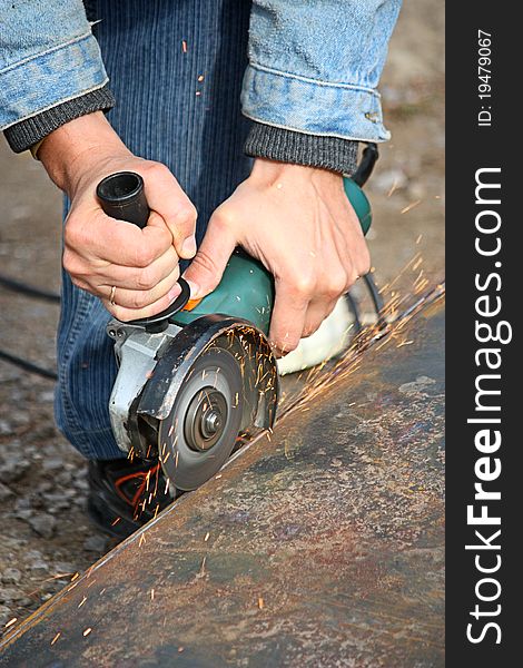 A worker cuts a metal by grinding wheel. A worker cuts a metal by grinding wheel