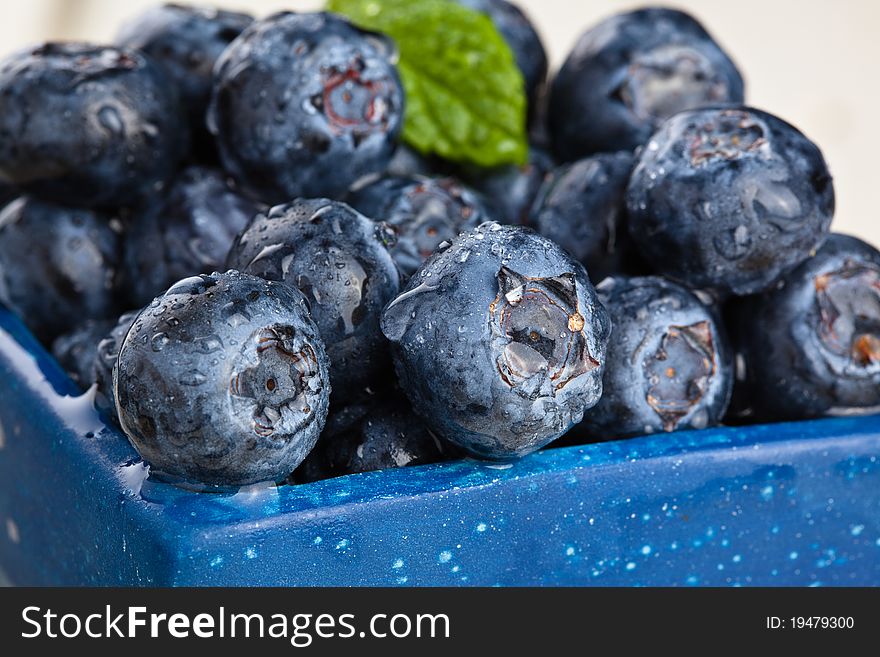 Blueberries in a small blue container. Blueberries in a small blue container