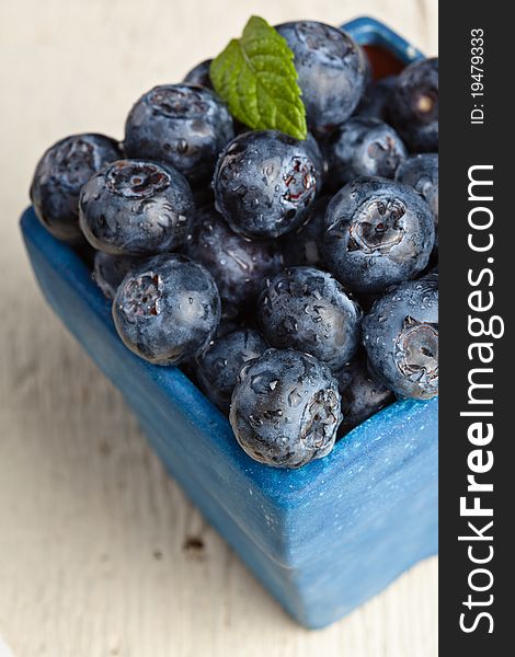 Blueberries in a small blue container. Blueberries in a small blue container