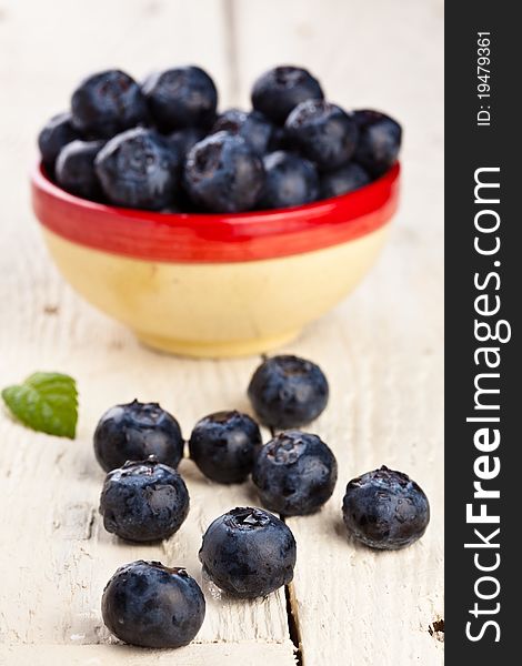 Blueberries in a small container on a wooden table. Blueberries in a small container on a wooden table