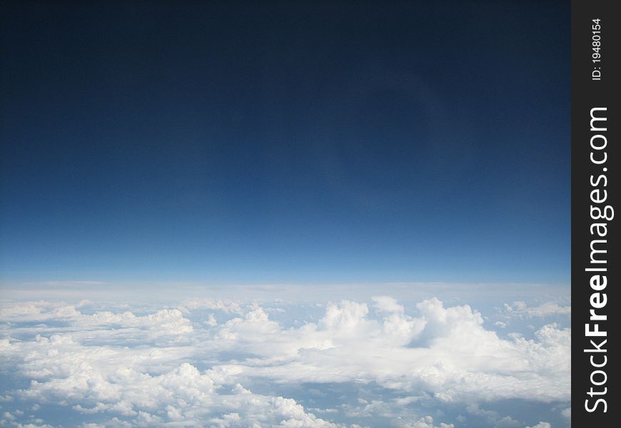 Large white clouds above the horizon seen from a plane