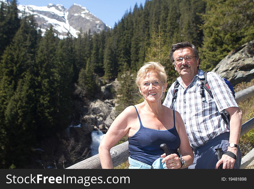 Senior couple hiking in a beautiful alpine setting. Active man and woman. Senior couple hiking in a beautiful alpine setting. Active man and woman.