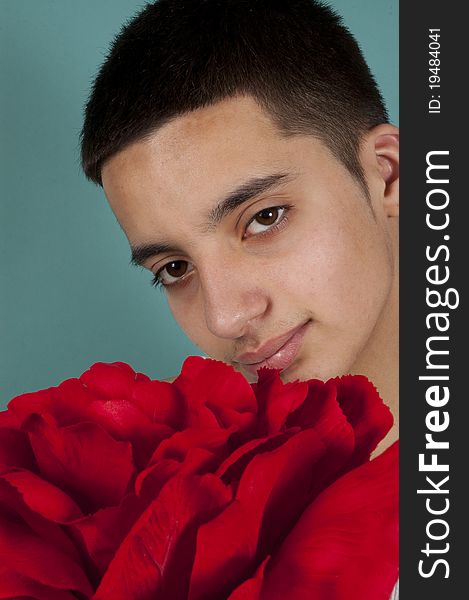 Teenage pakistani boy holding a big red rose;