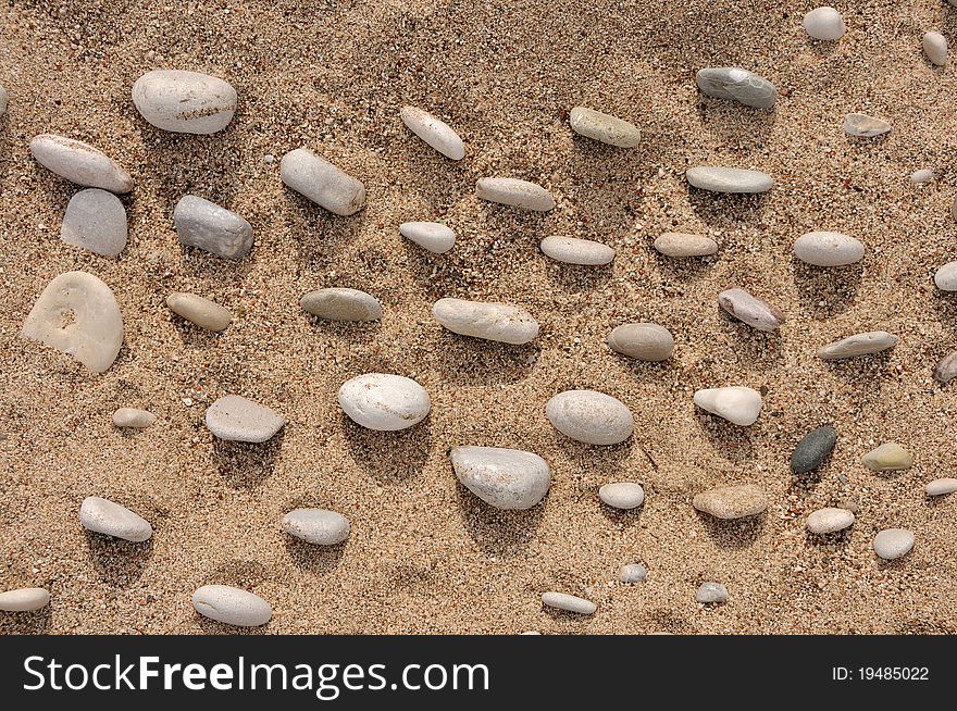 Beach on the summer light closeup with random pebbles. Beach on the summer light closeup with random pebbles
