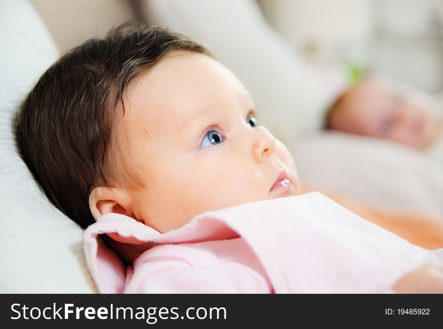 Beautiful Baby Girl Is Lying In A Bed.