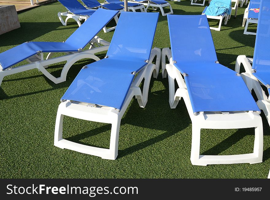 Blue chairs at poolside on turf