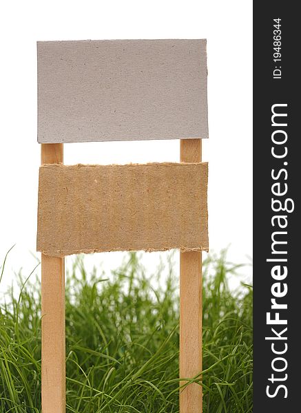 Cardboard sign with grass isolated on a white background