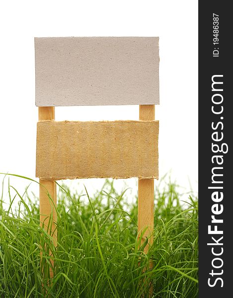 Cardboard sign with grass isolated on a white background