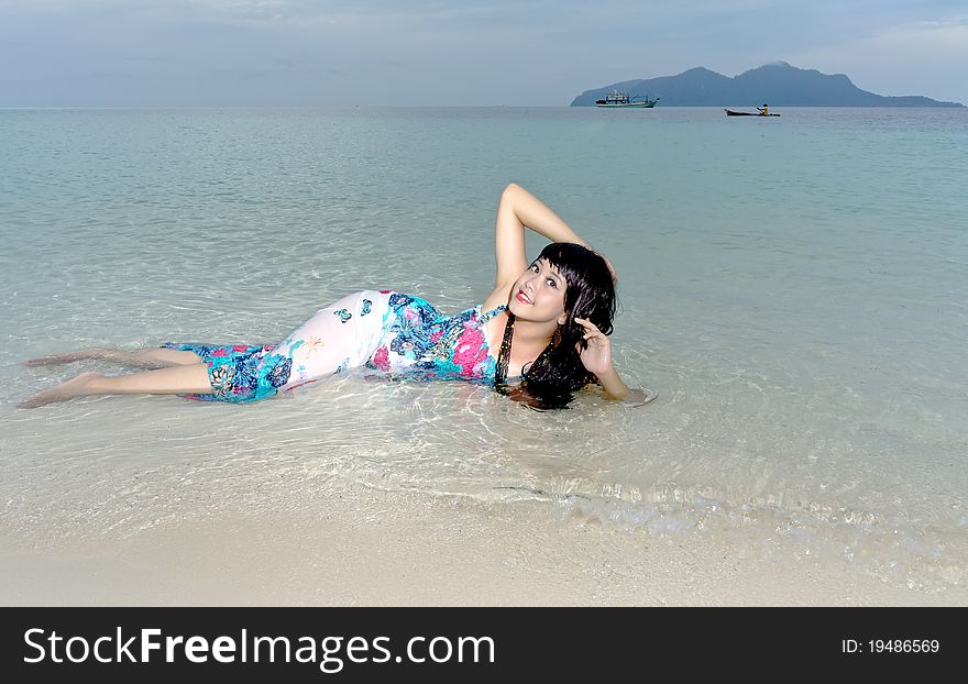 Young sensuality beautiful teen lays on clear crystal beach during holiday. Young sensuality beautiful teen lays on clear crystal beach during holiday