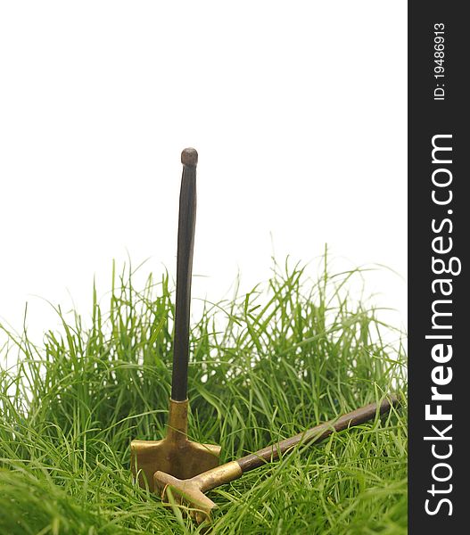 Green grass with garden tools isolated against a white background