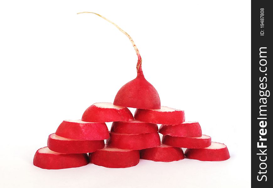 A red radish is cut groups, built as a pyramid on a white background. A red radish is cut groups, built as a pyramid on a white background
