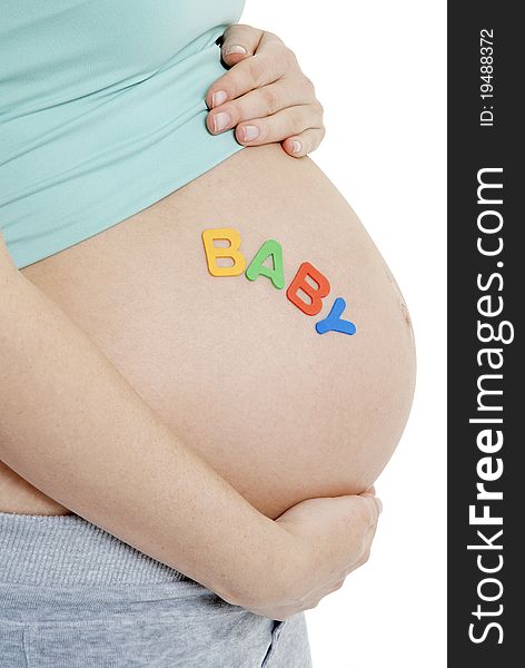 Close up of pregnant ladies tummy- BABY written. Close up of pregnant ladies tummy- BABY written