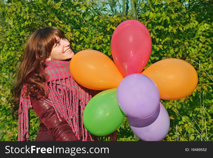 Girl with colorful balloons in park