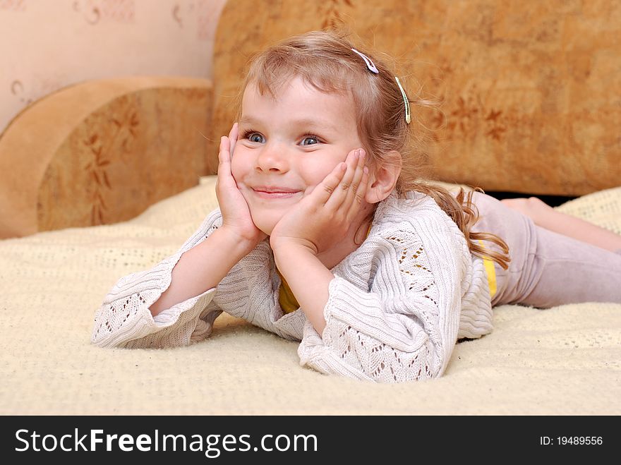 Portrait of a little girl. Young model playing on the bed. Portrait of a little girl. Young model playing on the bed