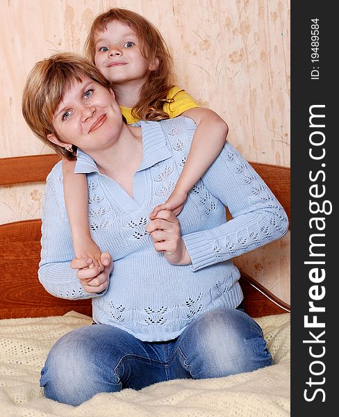 Happy mother and daughter playing on the bed. Happy mother and daughter playing on the bed