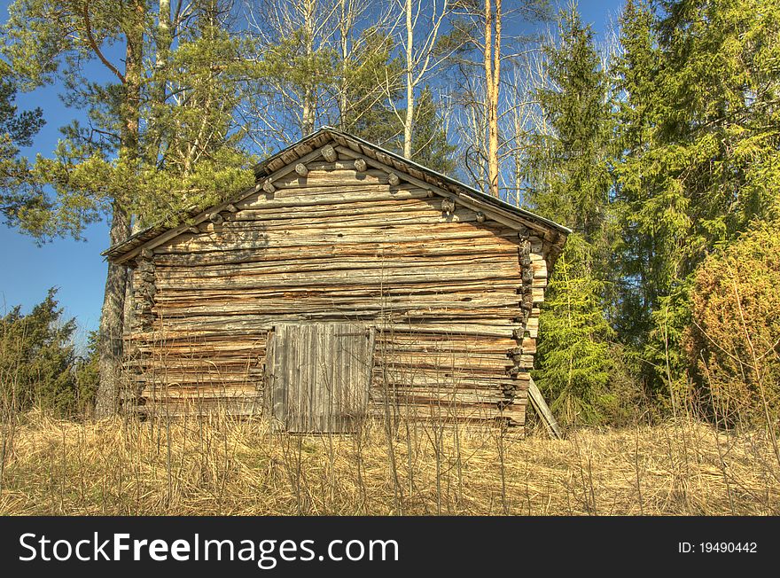 An old wooden country barn in the middle of the forest.