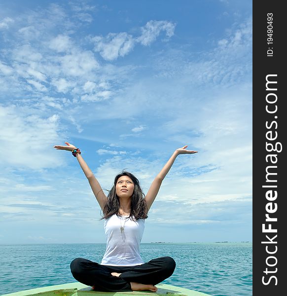 Pretty young sensuality girl performs as yoga move in front of moving boat during holiday