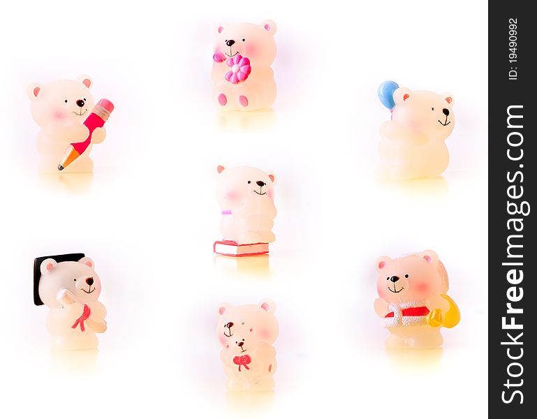 A collection of statues of seven lovely little bears, one is holding a pencil, one has a flower in the hand, one has a balloon, one is sitting on a book, one is at a graduation ceremony, one is holding her baby bear and the last one is dressing as the Santa Claus. Isolated on white background. A collection of statues of seven lovely little bears, one is holding a pencil, one has a flower in the hand, one has a balloon, one is sitting on a book, one is at a graduation ceremony, one is holding her baby bear and the last one is dressing as the Santa Claus. Isolated on white background.