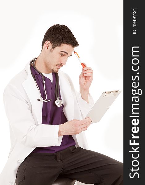 A male doctor is holding a chart and a pen thinking. A male doctor is holding a chart and a pen thinking.