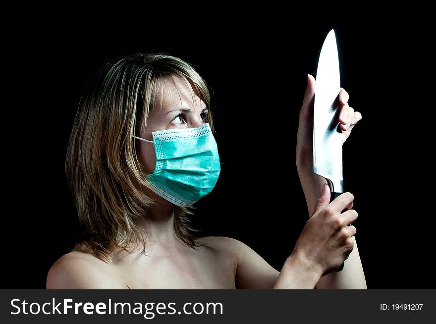 Woman with a knife on dark background
