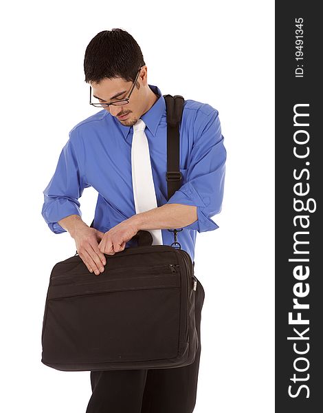 A man is looking in his business bag.  He is wearing a blue shirt and a tie. A man is looking in his business bag.  He is wearing a blue shirt and a tie.