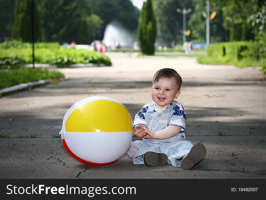 Little boy with a ball in a park smiling. Little boy with a ball in a park smiling