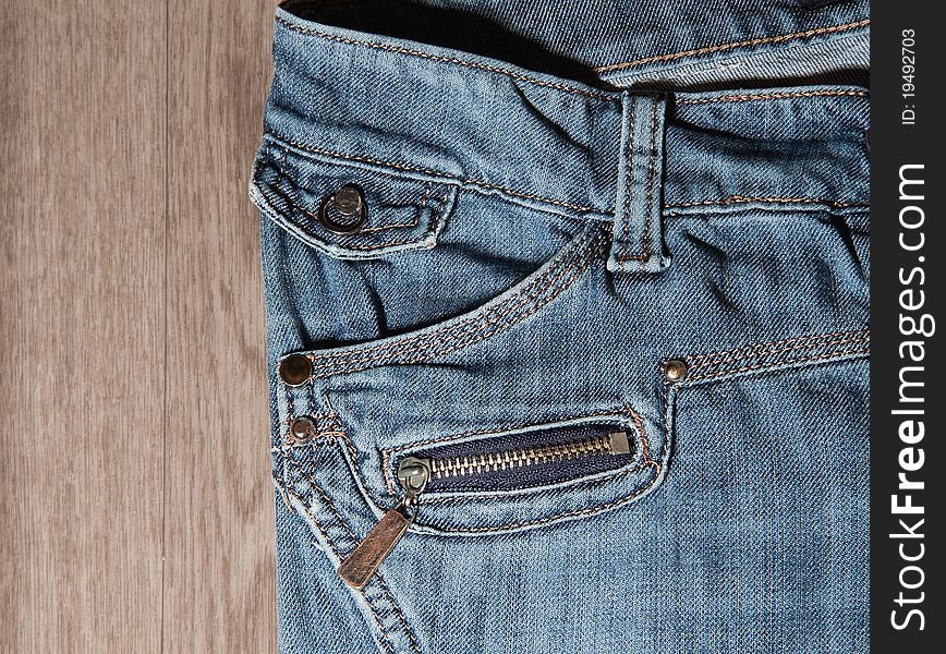Jeans pocket and zipper on background of wood