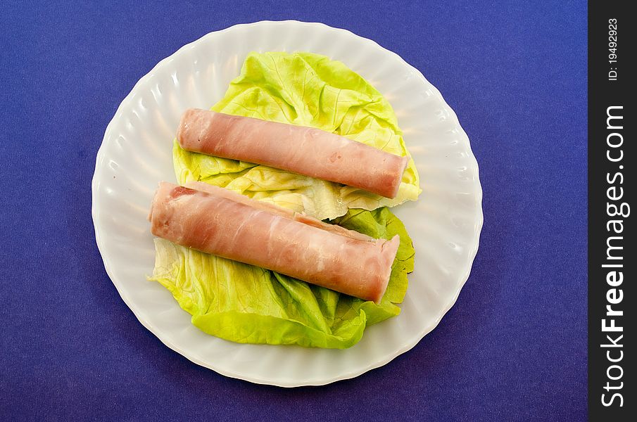 White plate with fresh lettuce and ham. White plate with fresh lettuce and ham