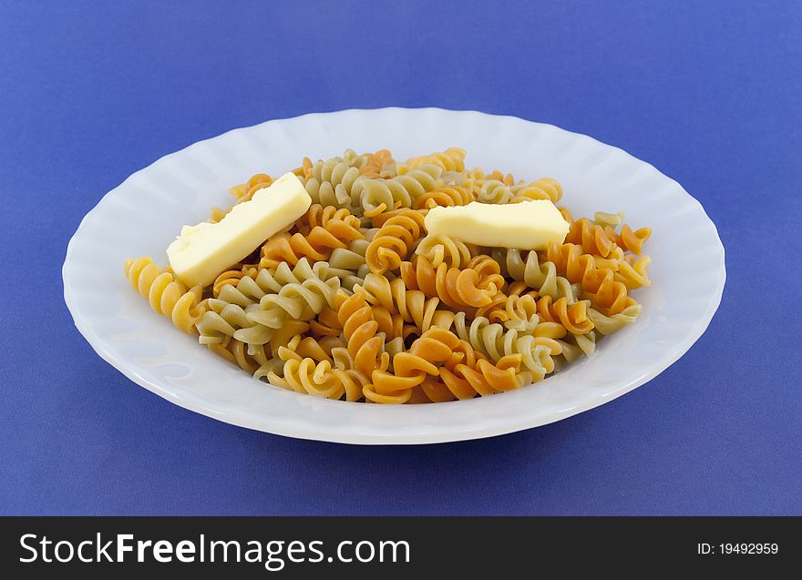 Colored noodle dish with pieces of butter. Colored noodle dish with pieces of butter
