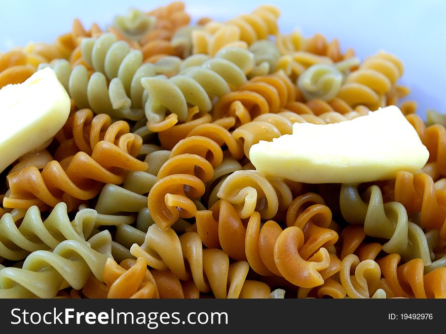 Colored pasta with pieces of butter