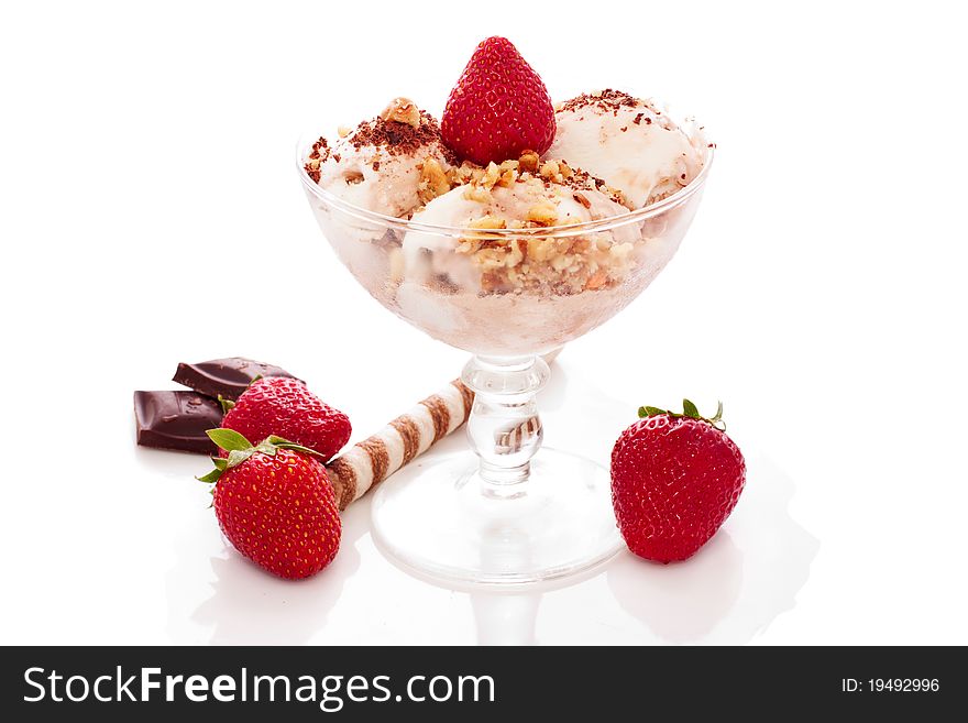 Ice cream with nuts and strawberry in a glass bowl over white