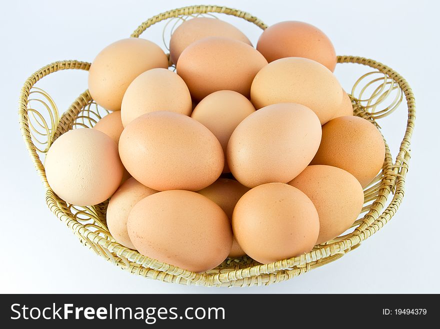 Chicken eggs in a basket in the middle of white background. Chicken eggs in a basket in the middle of white background