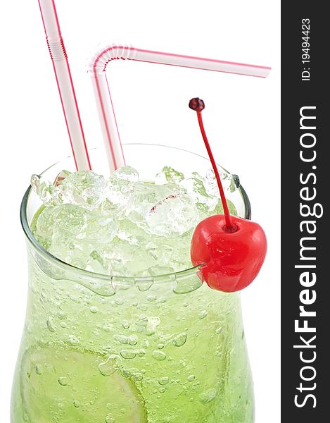 Green cocktail with a lemon and a cherry with ice and vials close up on a white background