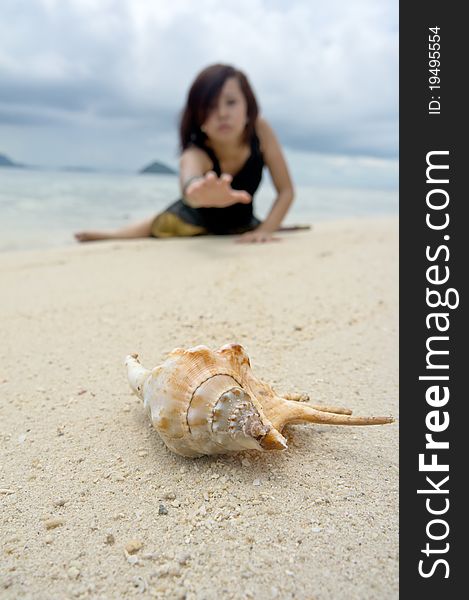 Photograph of a beautiful woman acting to grab the crab on beach during holiday. Photograph of a beautiful woman acting to grab the crab on beach during holiday