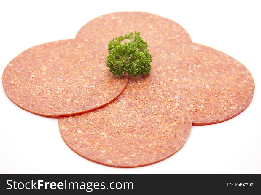 Paprika salami with parsley onto white background