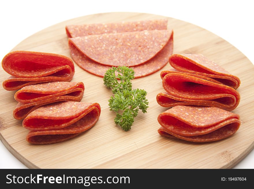 Paprika salami with parsley onto wood plates. Paprika salami with parsley onto wood plates