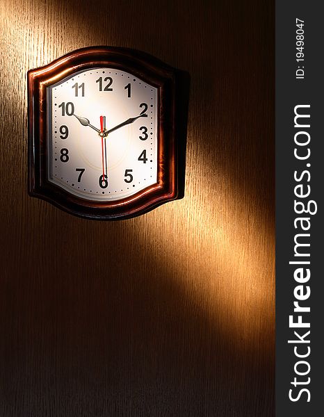 Clock hanging on wooden wall with beam of light. Clock hanging on wooden wall with beam of light