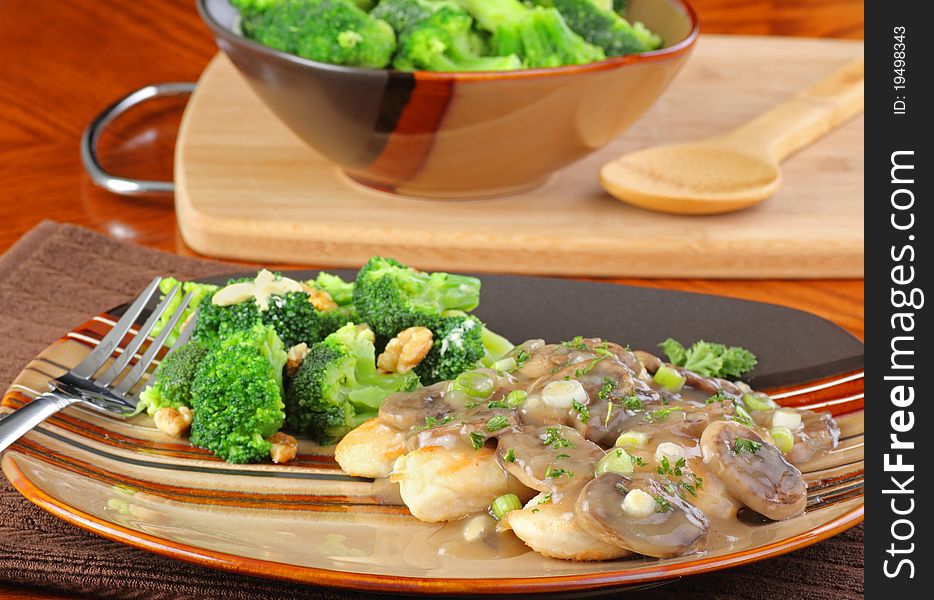 Chicken covered with mushroom and onion gravy and broccoli. Chicken covered with mushroom and onion gravy and broccoli