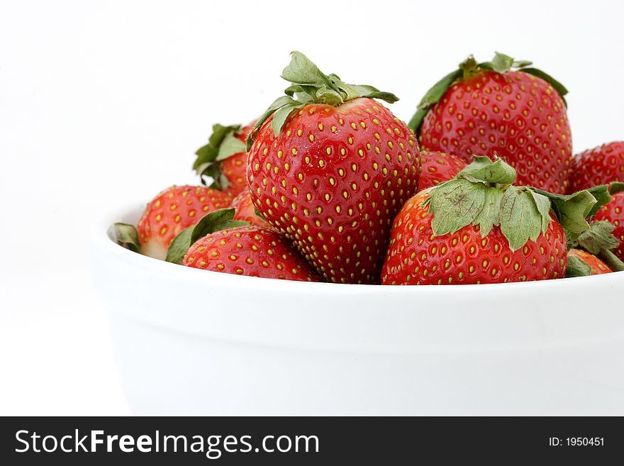 Close-up bowl of ripe strawberries in a white bowl on white background. Close-up bowl of ripe strawberries in a white bowl on white background