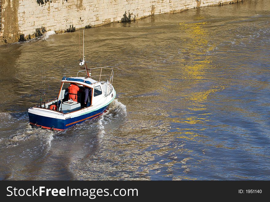 Blue and white fishing boat leaves a wake