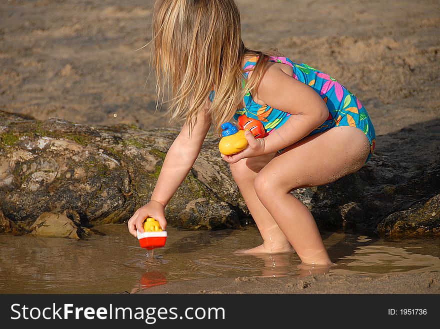 A girl is playing with toys on a beach