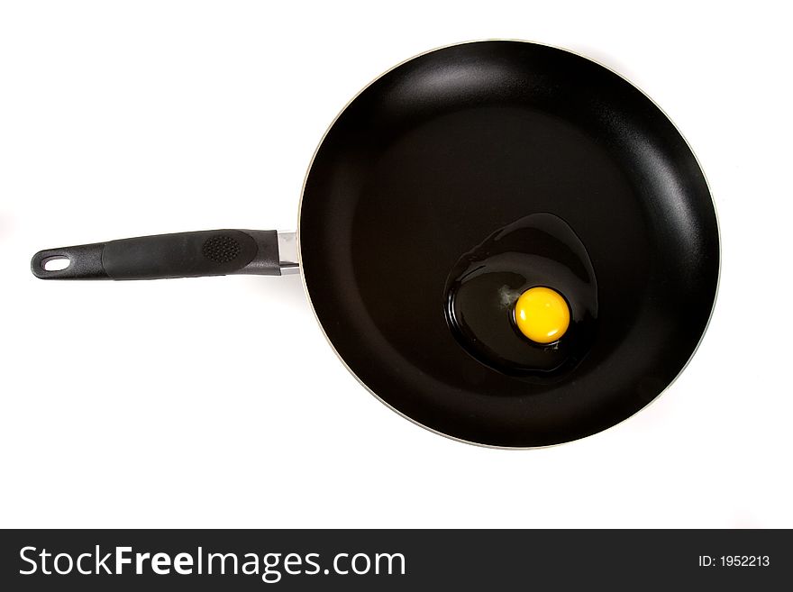 Over head shot of a raw egg on a frying pan. Over head shot of a raw egg on a frying pan
